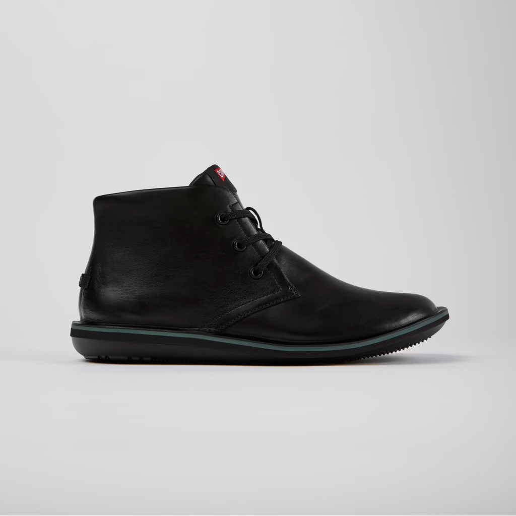 Black leather boot on a light gray background