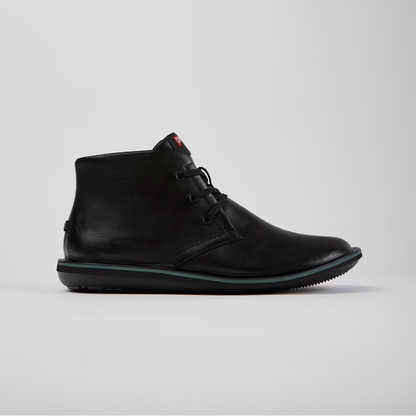 Black leather boot on a light gray background