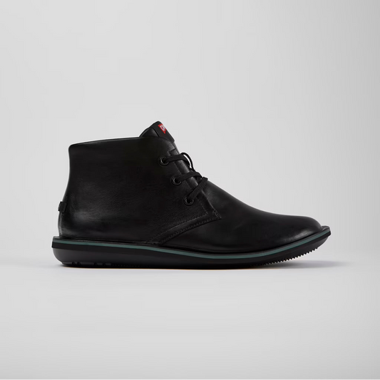 Black leather boot on a light gray background