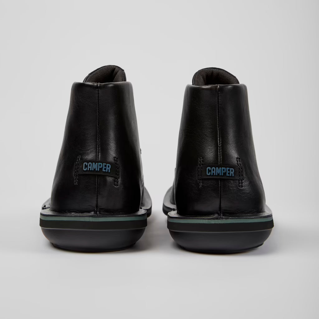 Black shoes with 'Camper' branding on a white background
