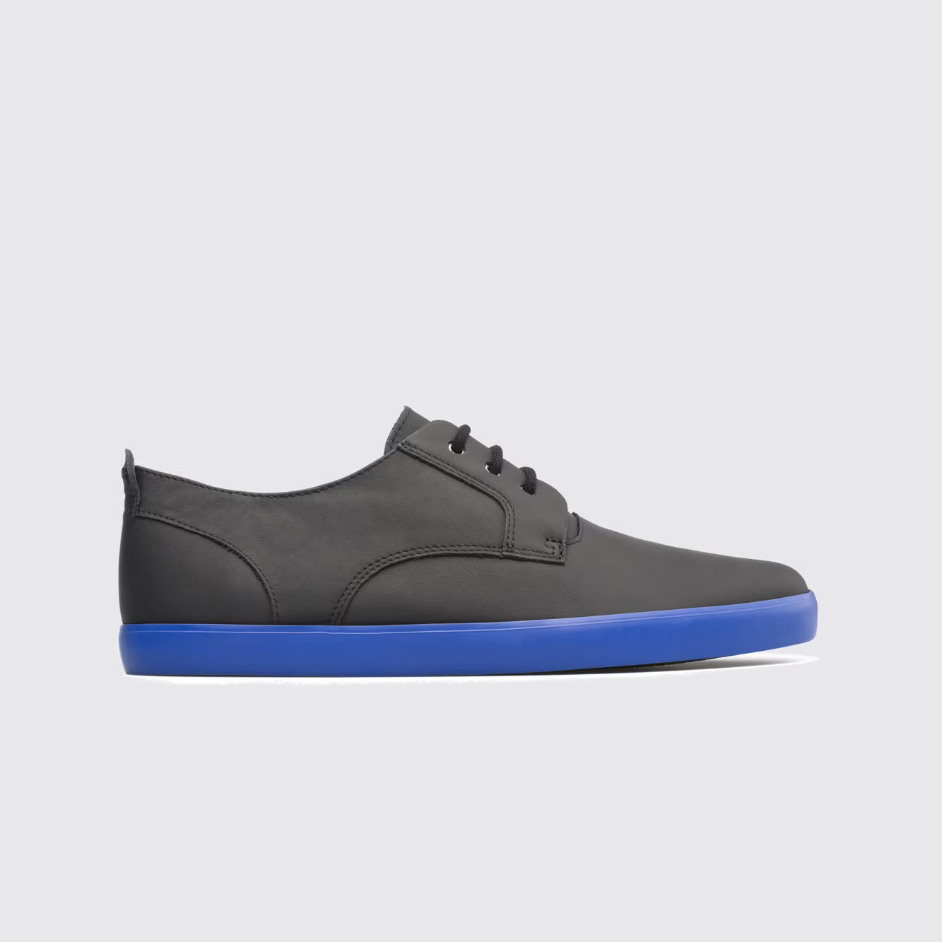 Gray sneaker with a blue sole on a light gray background