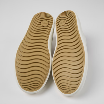 Pair of beige shoe soles on a white background