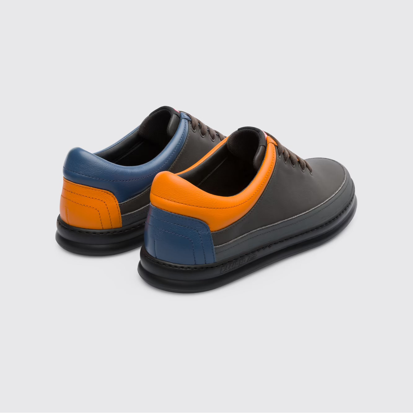 Pair of black and orange shoes on a light gray background