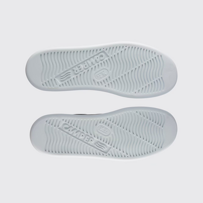 Gray sneaker soles with brand logo on a light gray background