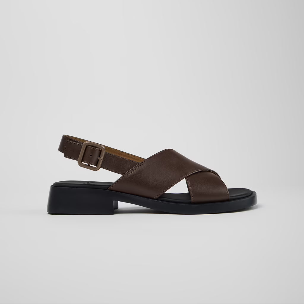 Brown sandal with a black sole on a light gray background