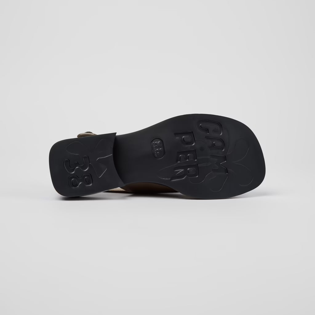 Black sandal with brand name on a light gray background