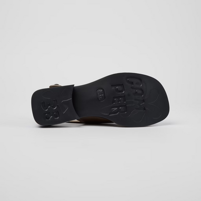 Black sandal with brand name on a light gray background